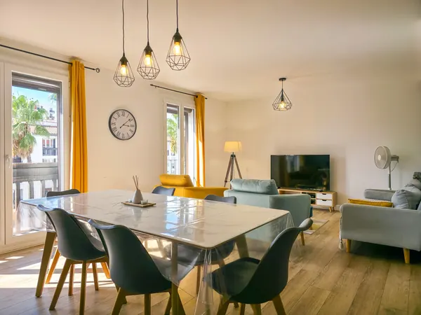 Séjour lumineux avec table dressée et chaises vertes
