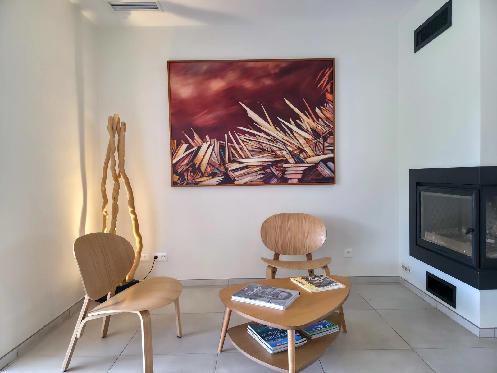 Coin salon avec fauteuils en bois, table basse et cheminée