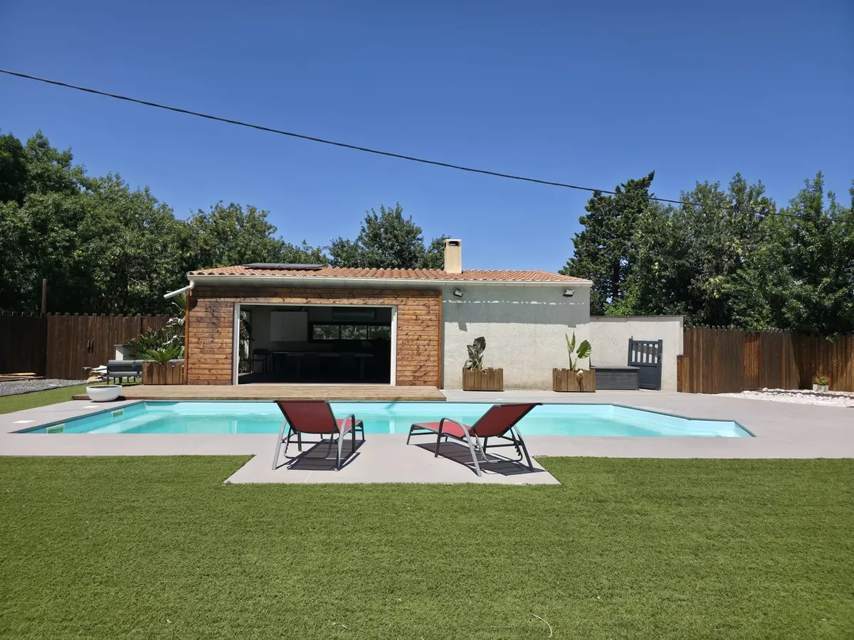 Maison de plain-pied avec piscine, transats et jardin